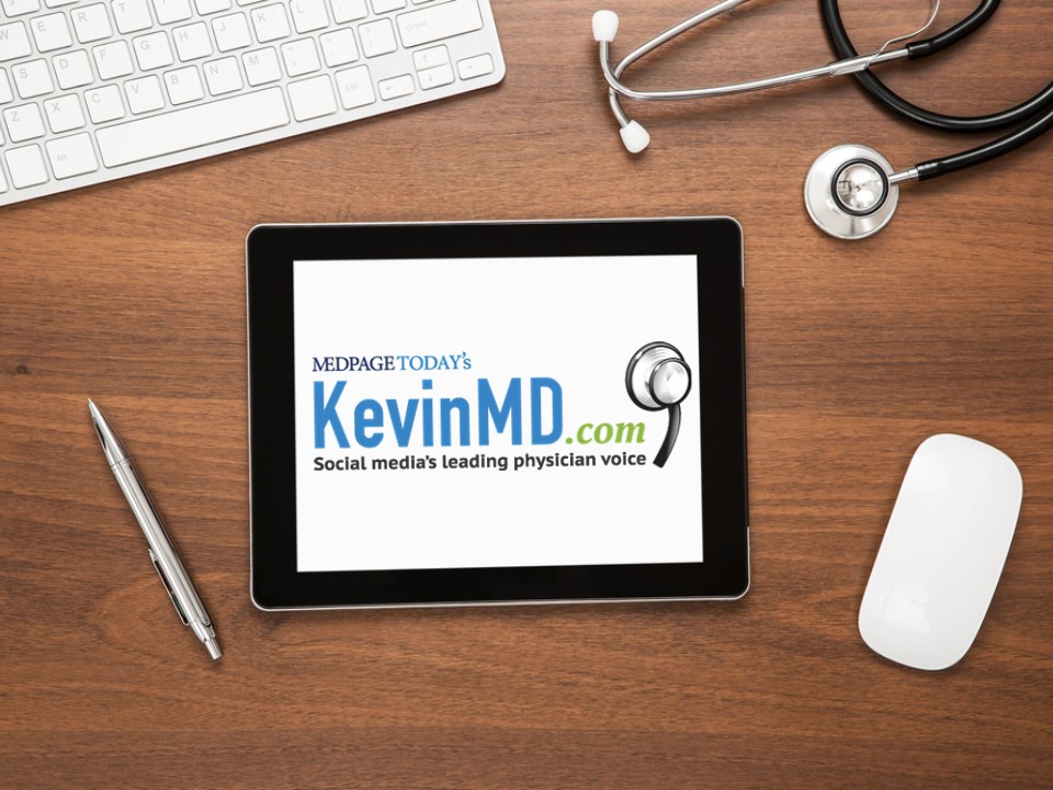 a desk with keyboard and ipad with the kevinmd logo